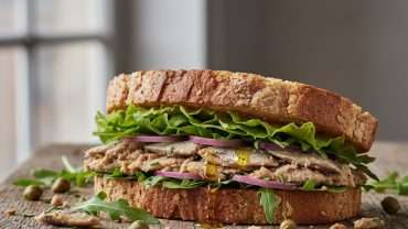 Healthy Mediterranean sardine sandwich with arugula and lemon on toasted bread"